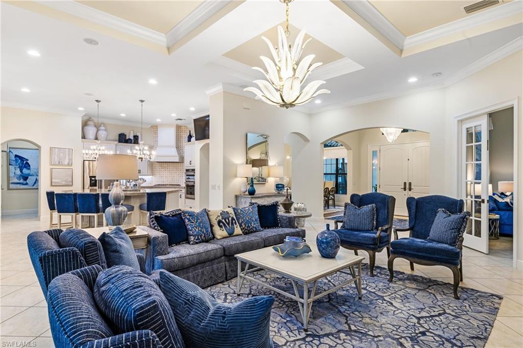 14480 Marsala Way Naples, FL 34109 - Photo 2 of 31 a living room with furniture a fireplace and a chandelier