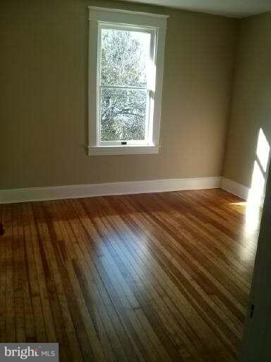 646 Orpington Road Baltimore, MD 21229 - Photo 15 of 30 a view of an empty room with wooden floor and a window