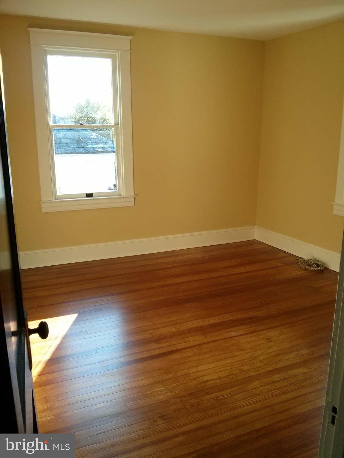 646 Orpington Road Baltimore, MD 21229 - Photo 16 of 30 an empty room with wooden floor and windows