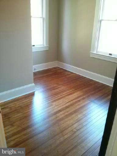 646 Orpington Road Baltimore, MD 21229 - Photo 17 of 30 an empty room with wooden floor and windows