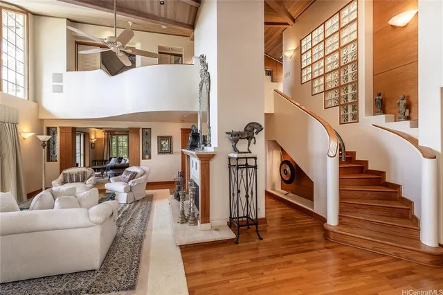 a living room with wooden floor furniture and a chandelier