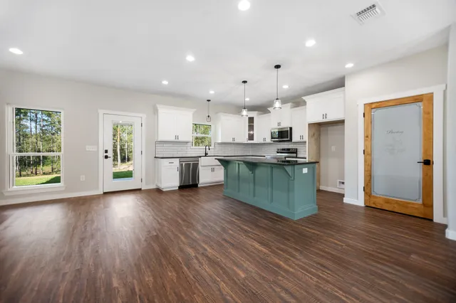 a kitchen with stainless steel appliances granite countertop a stove microwave and refrigerator