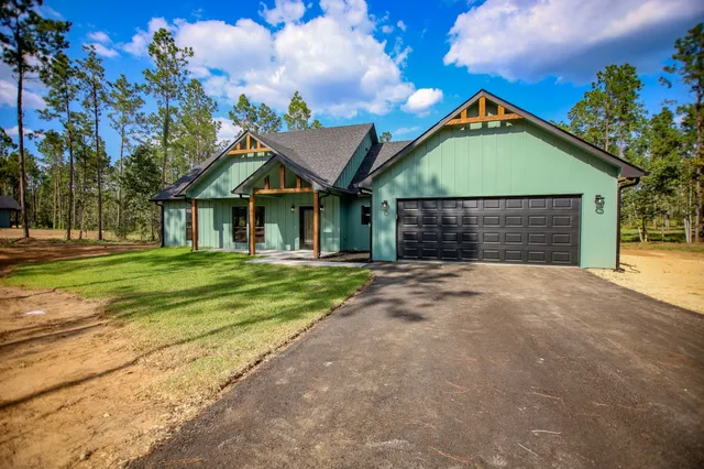 a view of a house with a small yard and wooden fence