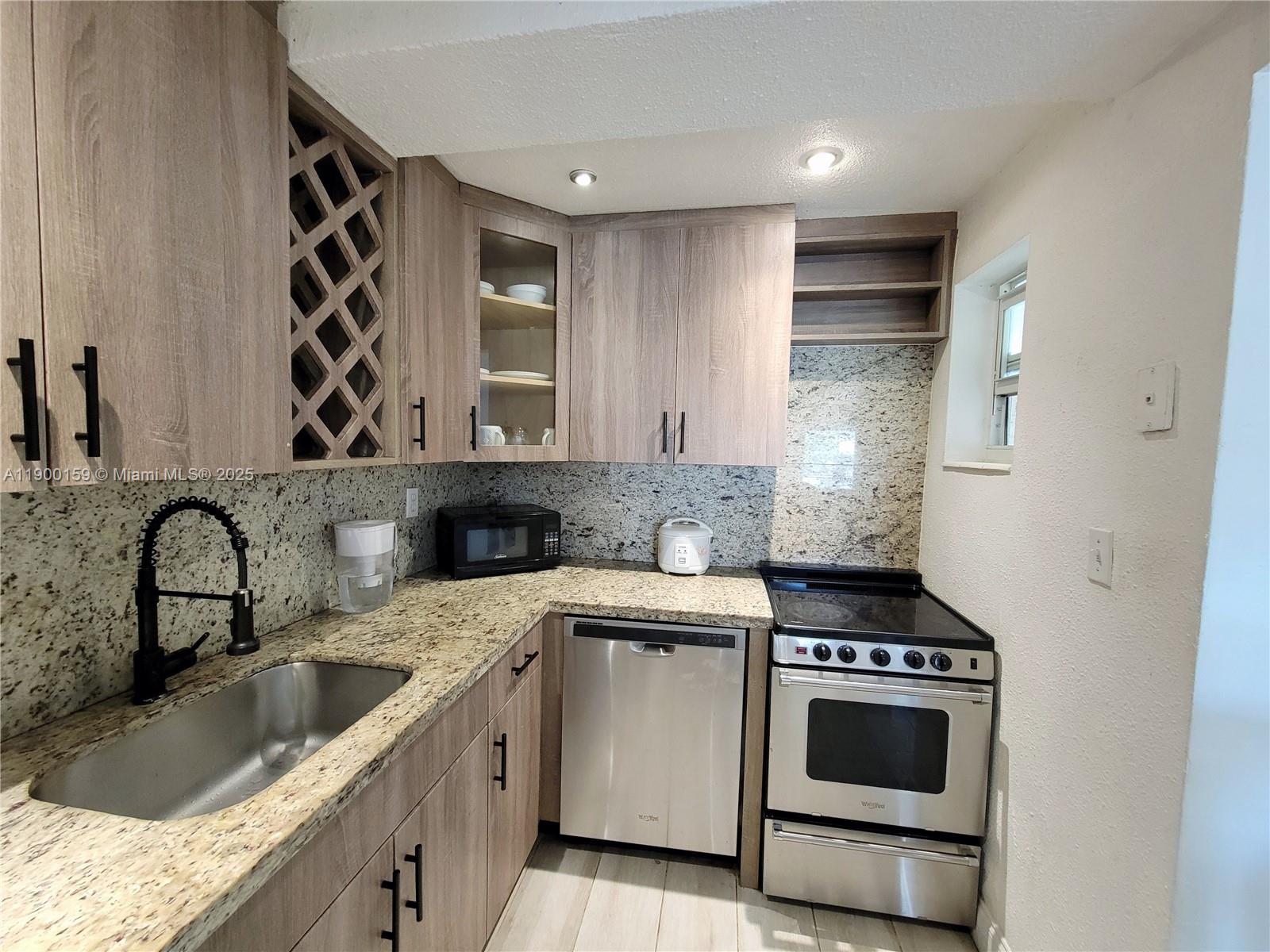 8609 Southwest 68th Court, Unit 5 Pinecrest, FL 33156 - Photo 1 of 35 a kitchen with a sink stove top oven and cabinets