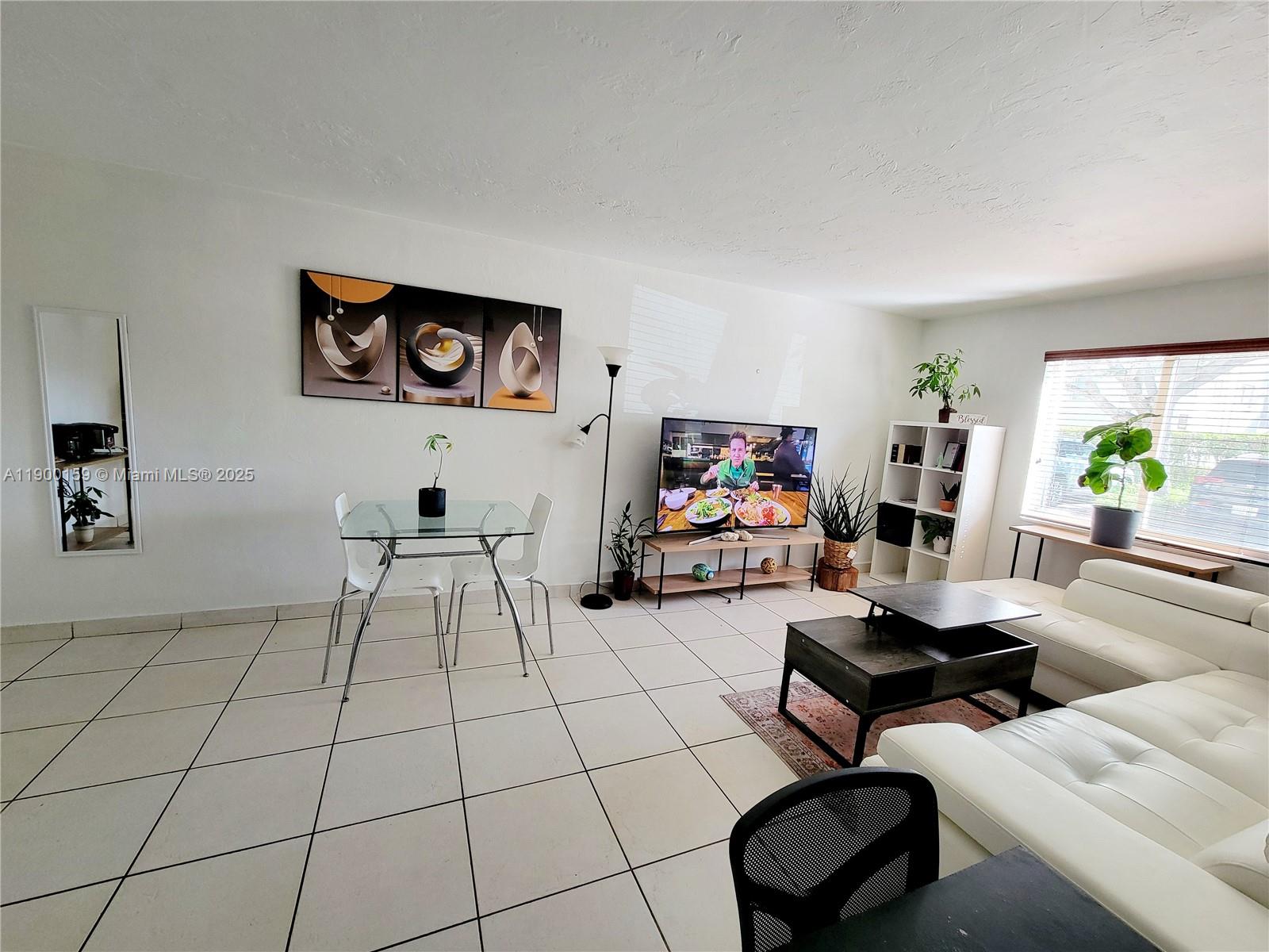 8609 Southwest 68th Court, Unit 5 Pinecrest, FL 33156 - Photo 11 of 35 a living room with furniture and a flat screen tv