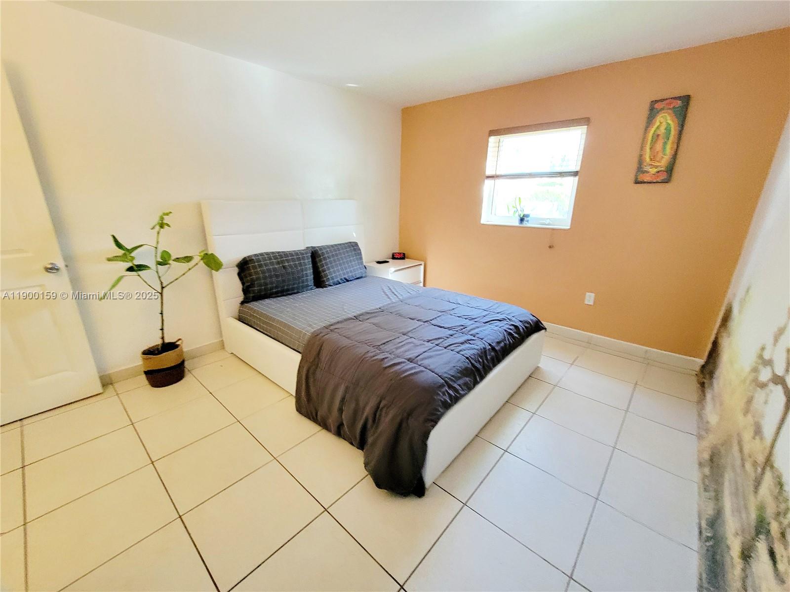 8609 Southwest 68th Court, Unit 5 Pinecrest, FL 33156 - Photo 13 of 35 a bedroom with a bed and a window