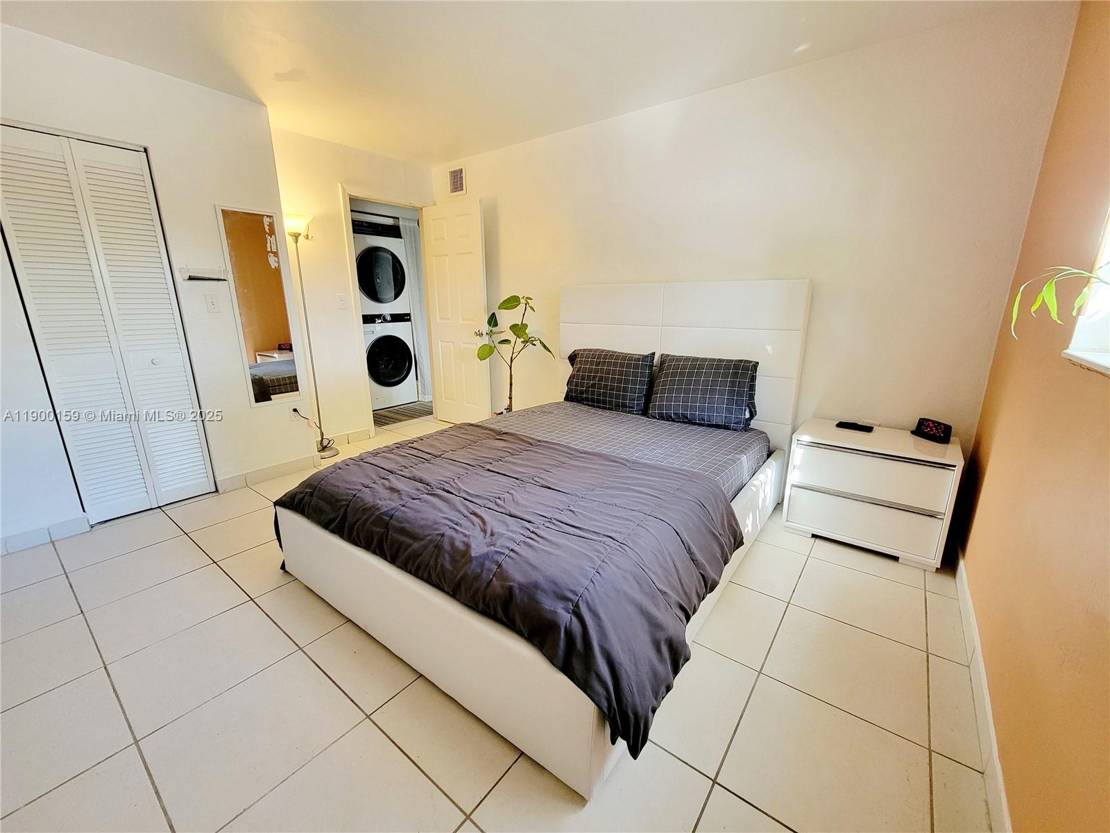 8609 Southwest 68th Court, Unit 5 Pinecrest, FL 33156 - Photo 14 of 35 a bedroom with a bed and a window