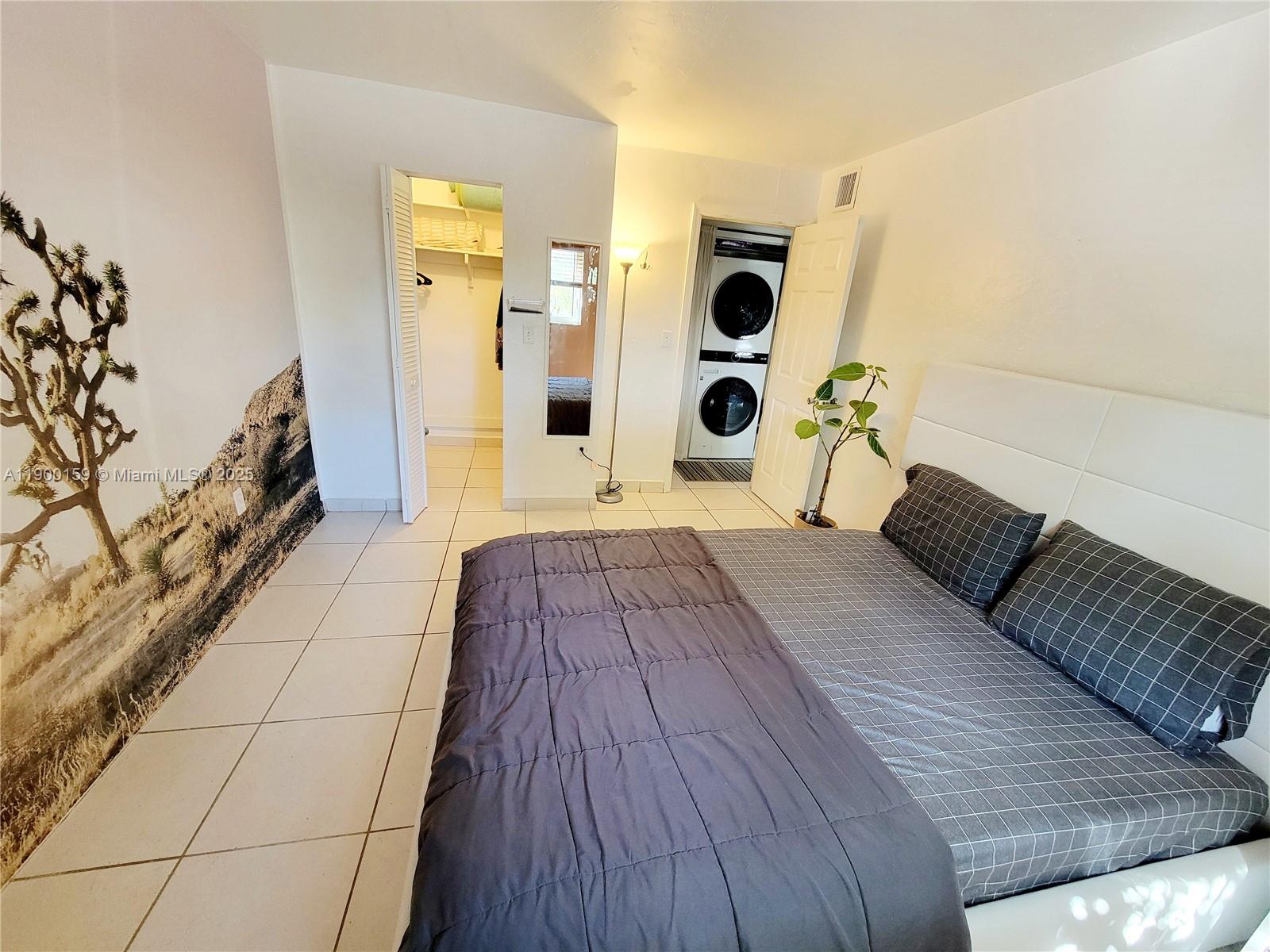 8609 Southwest 68th Court, Unit 5 Pinecrest, FL 33156 - Photo 16 of 35 a spacious bedroom with a bed and a mirror