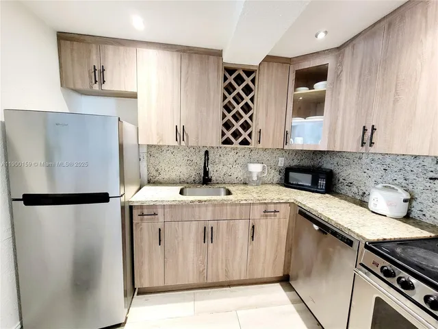 a kitchen with stainless steel appliances a sink a stove and a refrigerator