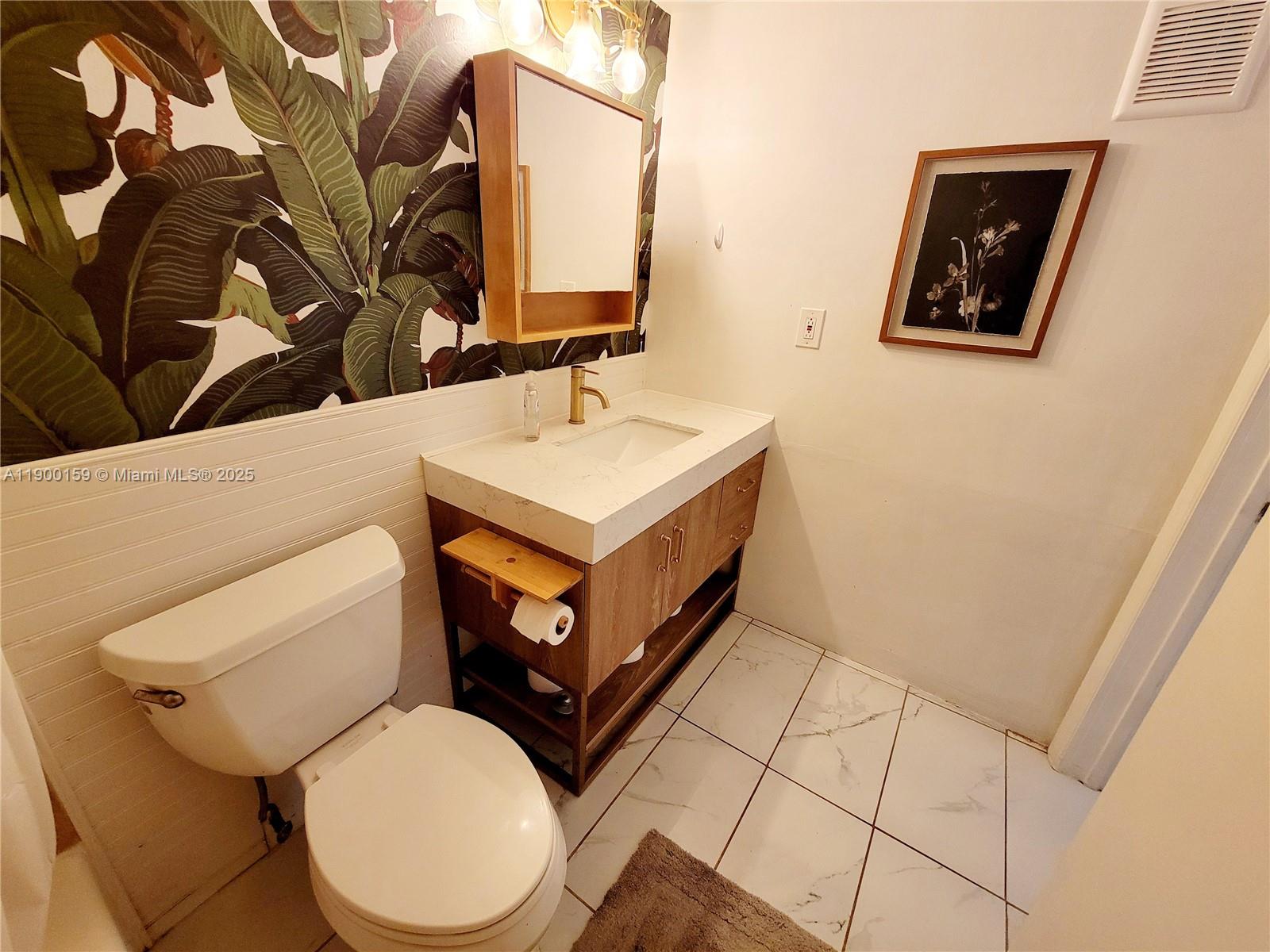 8609 Southwest 68th Court, Unit 5 Pinecrest, FL 33156 - Photo 22 of 35 a bathroom with a toilet sink and mirror