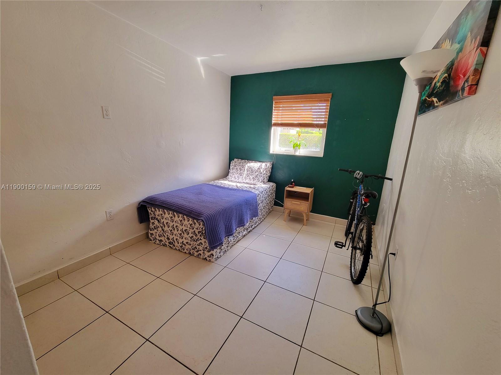 8609 Southwest 68th Court, Unit 5 Pinecrest, FL 33156 - Photo 23 of 35 a bedroom with a bed and a window