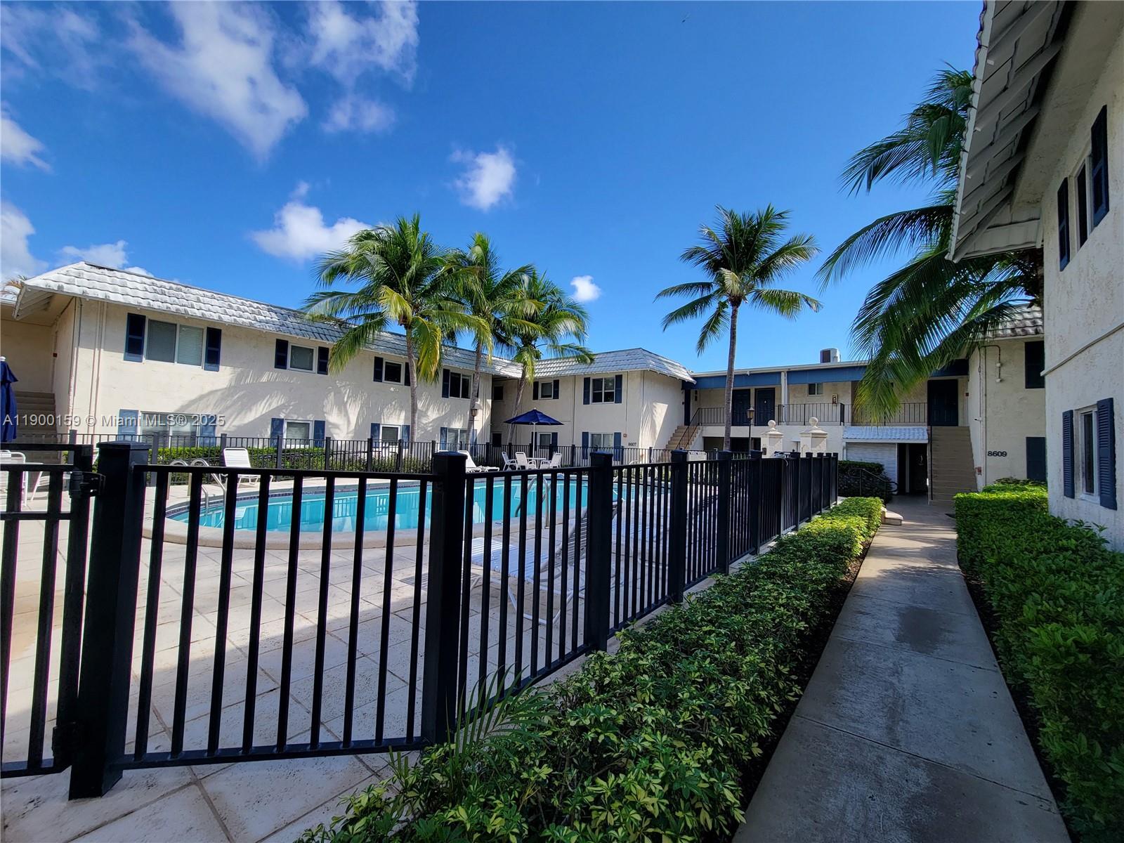 8609 Southwest 68th Court, Unit 5 Pinecrest, FL 33156 - Photo 30 of 35 a view of a house with a yard and potted plants