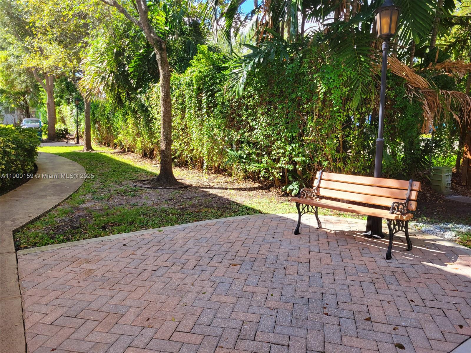 8609 Southwest 68th Court, Unit 5 Pinecrest, FL 33156 - Photo 32 of 35 a park view with a bench and trees