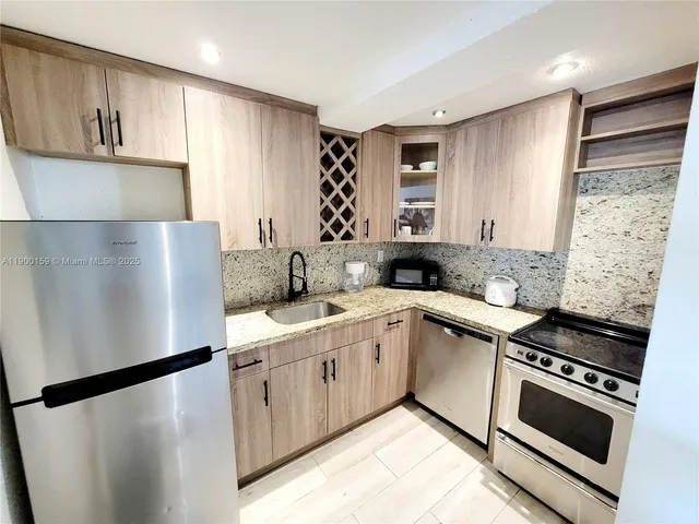a kitchen with stainless steel appliances a refrigerator sink and cabinets