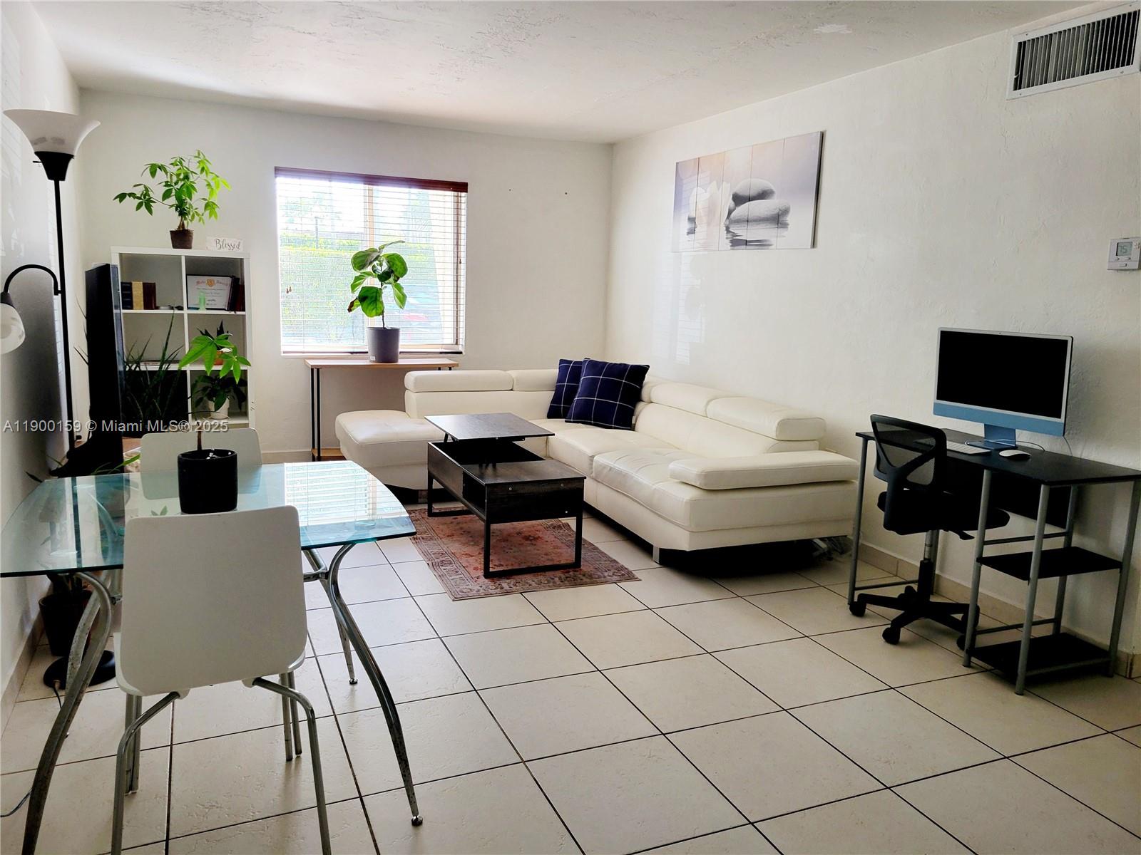 8609 Southwest 68th Court, Unit 5 Pinecrest, FL 33156 - Photo 7 of 35 a living room with furniture and a flat screen tv