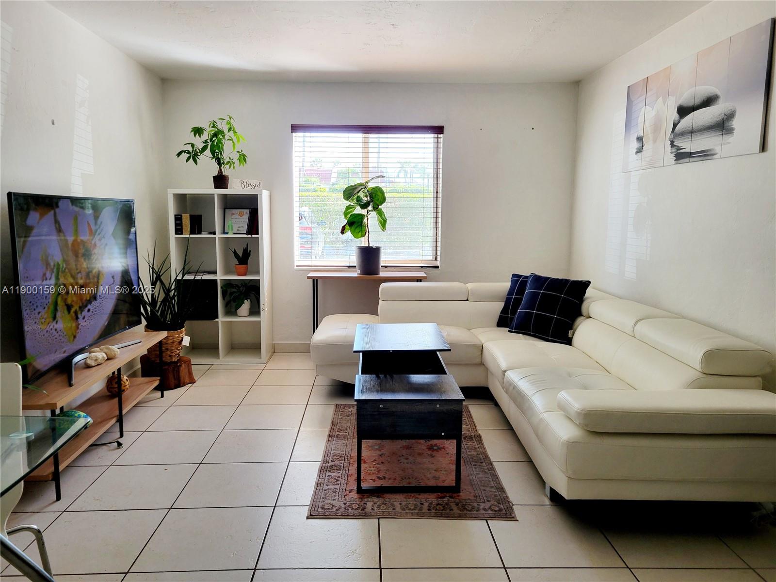 8609 Southwest 68th Court, Unit 5 Pinecrest, FL 33156 - Photo 8 of 35 a living room with furniture and a flat screen tv