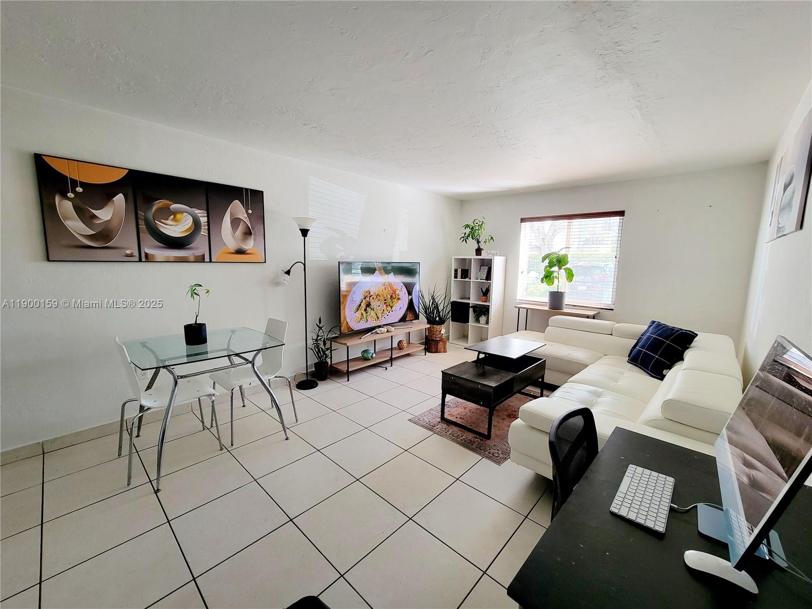 8609 Southwest 68th Court, Unit 5 Pinecrest, FL 33156 - Photo 9 of 35 a living room with furniture and a flat screen tv