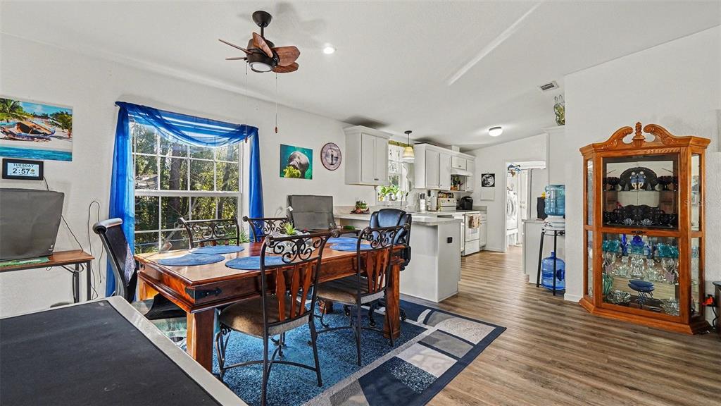 6300 East Sage Street Inverness, FL 34452 - Photo 9 of 32 a living room with furniture a wooden floor and a chandelier