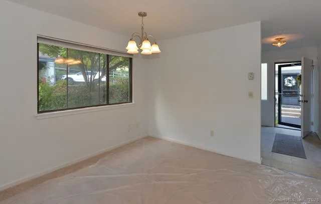 en empty room with windows and chandelier