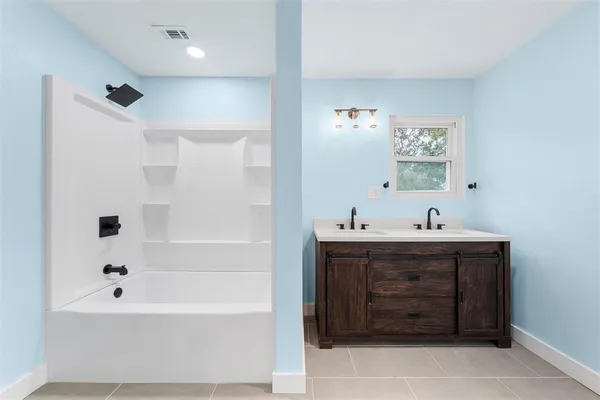 a bathroom with a tub sink and mirror