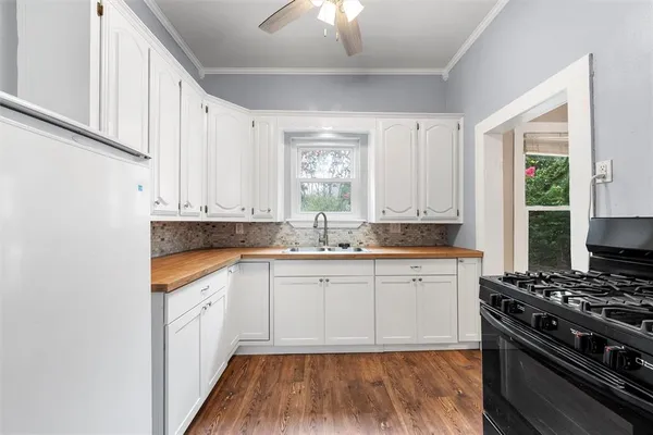 a kitchen with granite countertop white cabinets and appliances