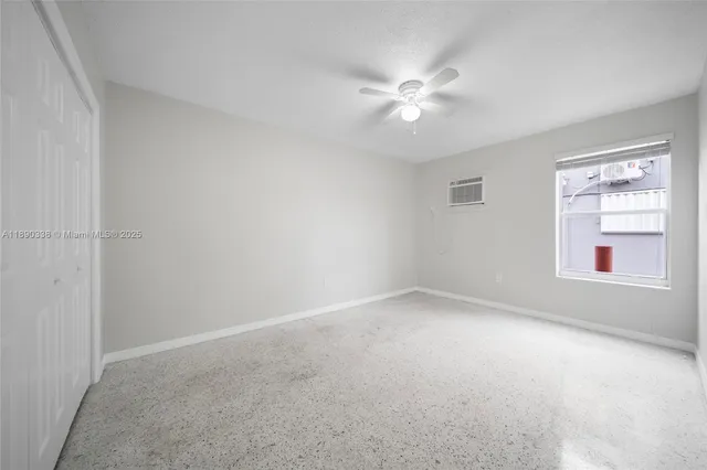 an empty room with an entryway and fan