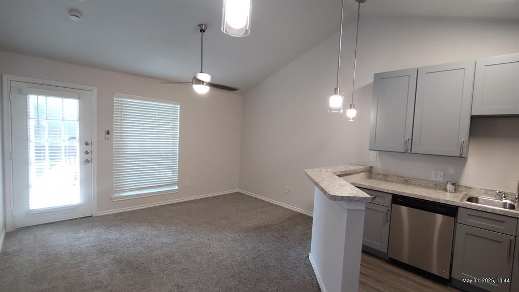 6108 Abrams Road, Unit 522 Dallas, TX 75231 - Photo 6 of 14 Kitchen featuring stainless steel dishwasher, gray cabinetry, lofted ceiling, a sink, and a ceiling fan
