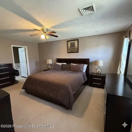 a bedroom with a bed mirror and a night stand