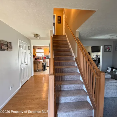 a view of a hallway with wooden floor and stairs
