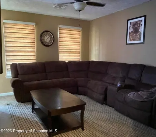 a living room with furniture a window and a clock