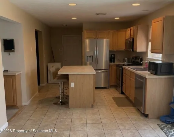a kitchen with stainless steel appliances a refrigerator sink and microwave