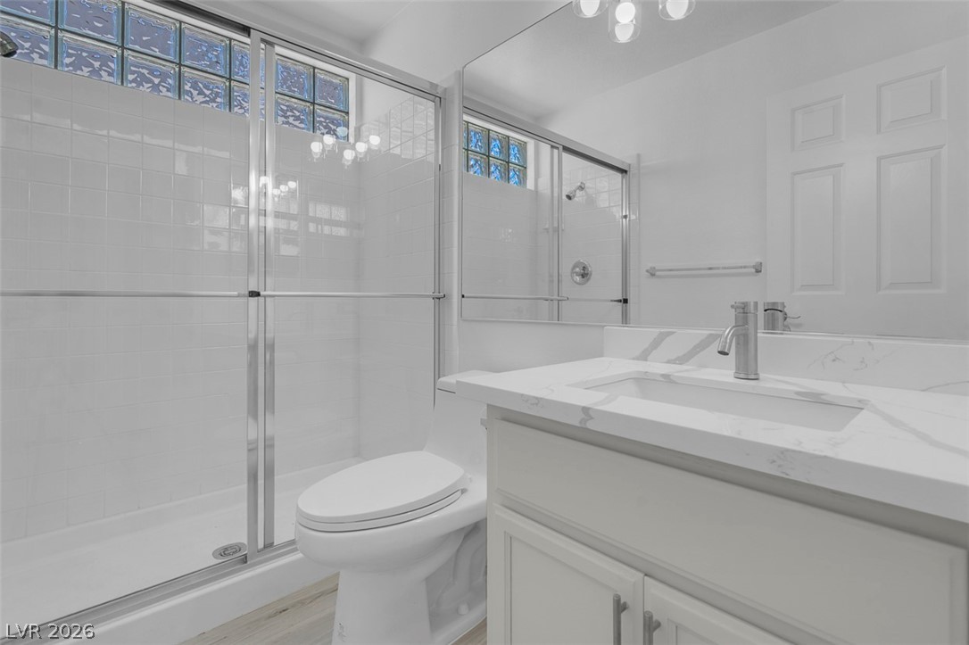 3604 North Campbell Road Las Vegas, NV 89129 - Photo 29 of 54 Full bath featuring a stall shower, toilet, vanity, and wood finished floors