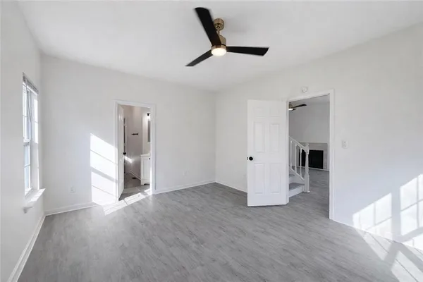 a view of empty room with wooden floor and window