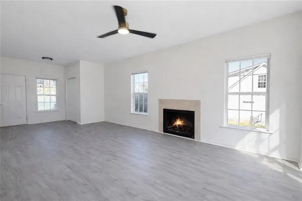 an empty room with windows and fireplace