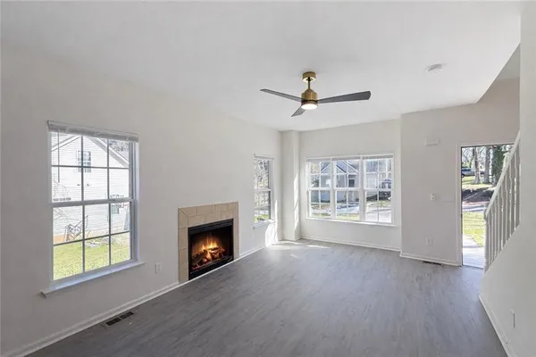 a view of an empty room with a window and fireplace