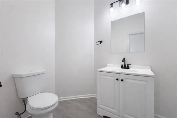 a bathroom with a toilet a sink and mirror