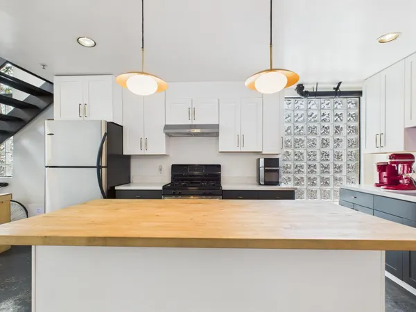a kitchen with stainless steel appliances a stove a sink and a refrigerator