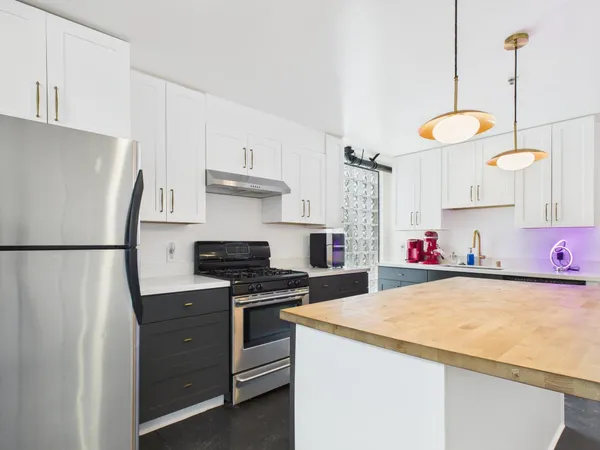 a kitchen with stainless steel appliances granite countertop a sink and a refrigerator