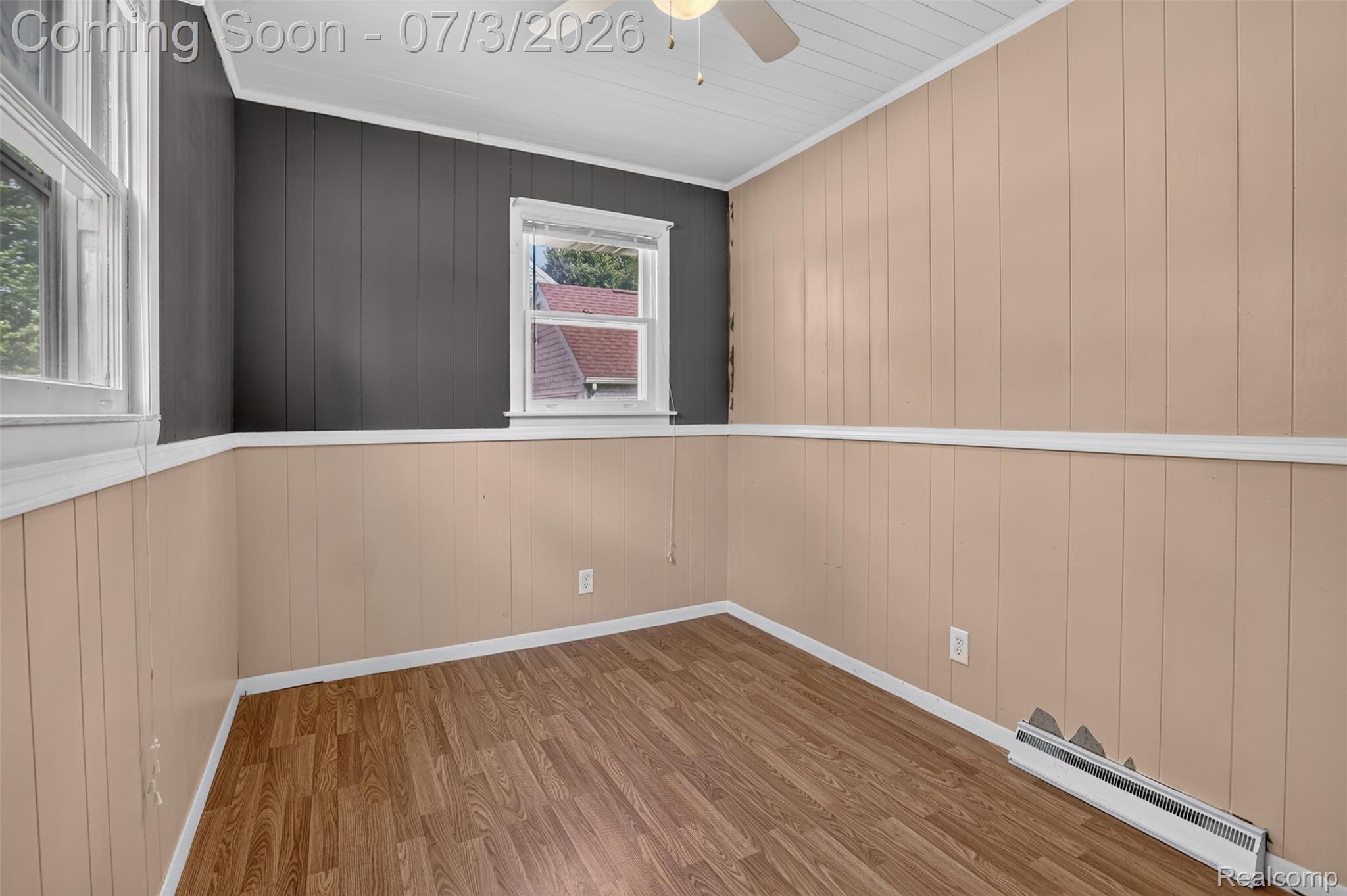 4322 Baker Road Bridgeport, MI 48722 - Photo 10 of 29 Room featuring wood-finish flooring, two windows with white trim, and a ceiling fan with integrated lighting