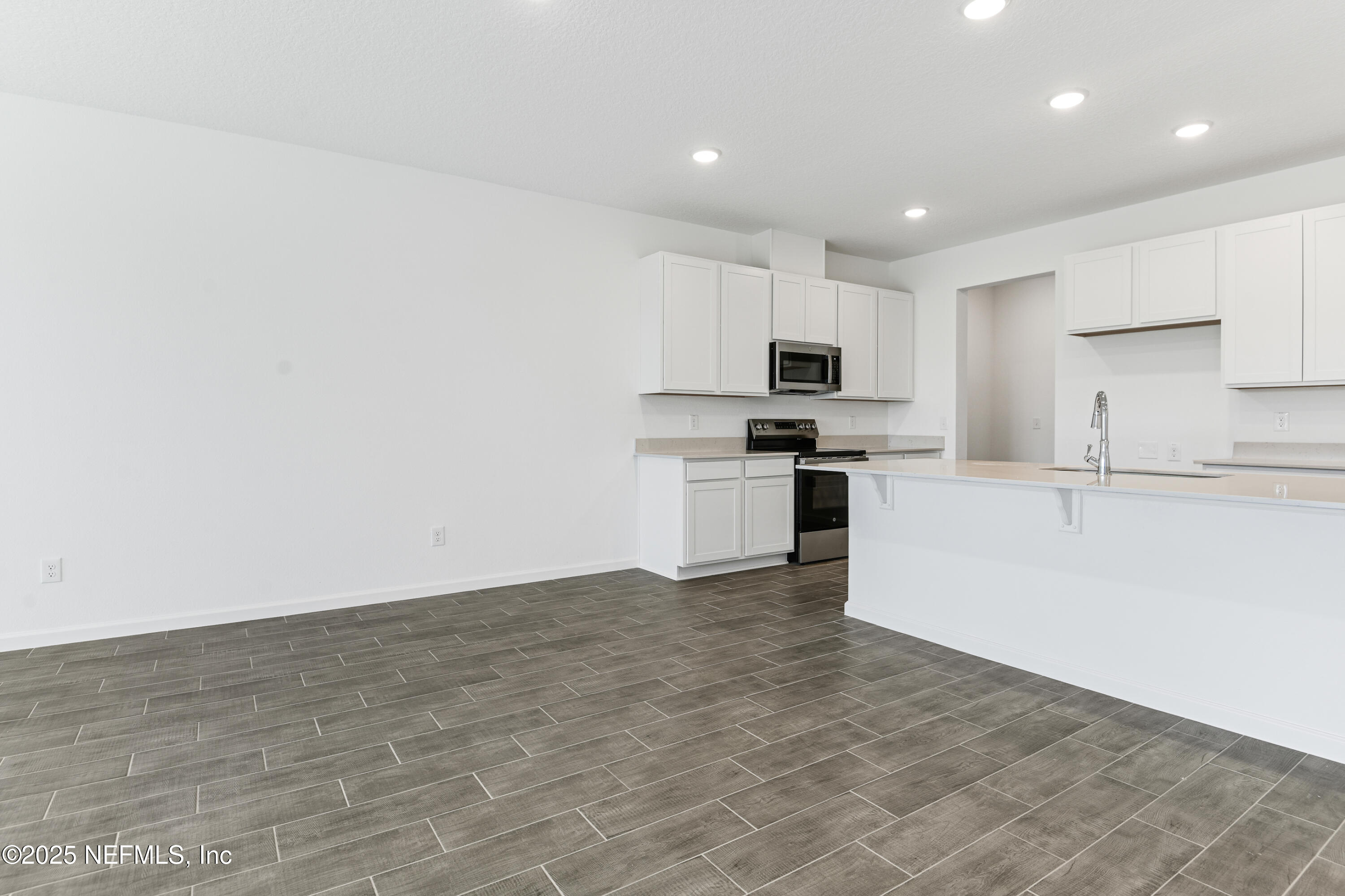 328 Alexandrite Street DeLand, FL 32720 - Photo 13 of 16 a kitchen with granite countertop a stove a sink and a refrigerator