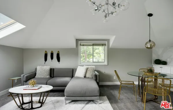 a living room with furniture a chandelier and a window