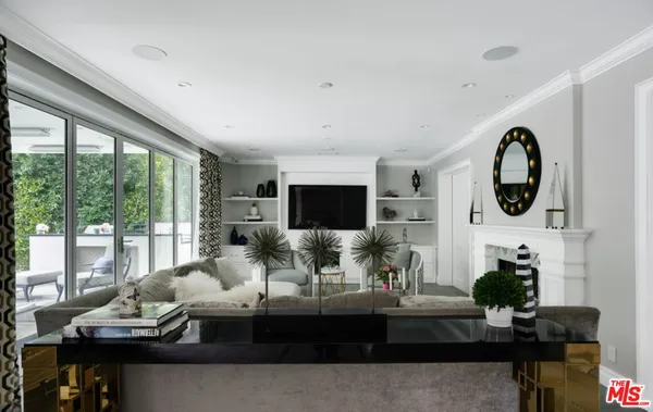 a living room with furniture a flat screen tv and a large window