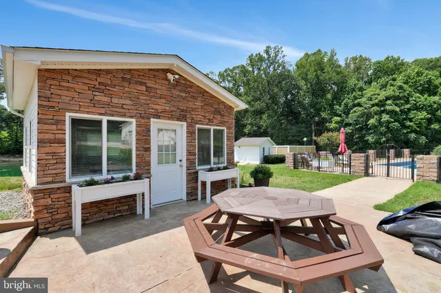 a view of a patio with table and chairs with wooden floor and fence