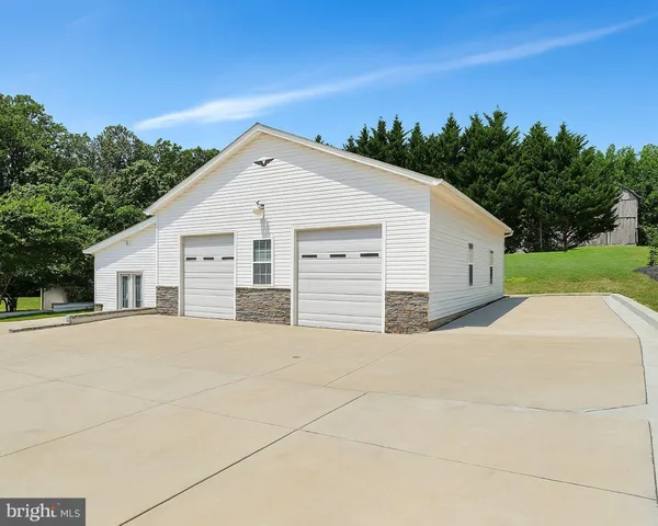 a view of a white house with a yard and large tree