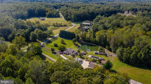 an aerial view of residential houses with outdoor space and trees