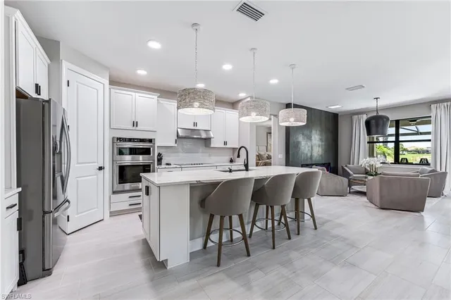 a kitchen with stainless steel appliances granite countertop a sink and refrigerator