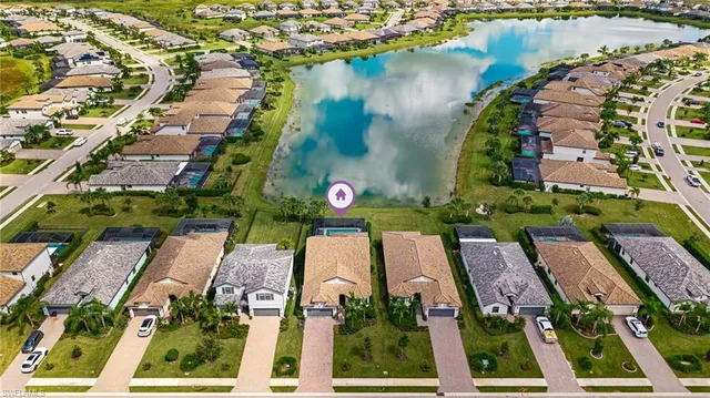 an aerial view of a residential houses with outdoor space and lake view