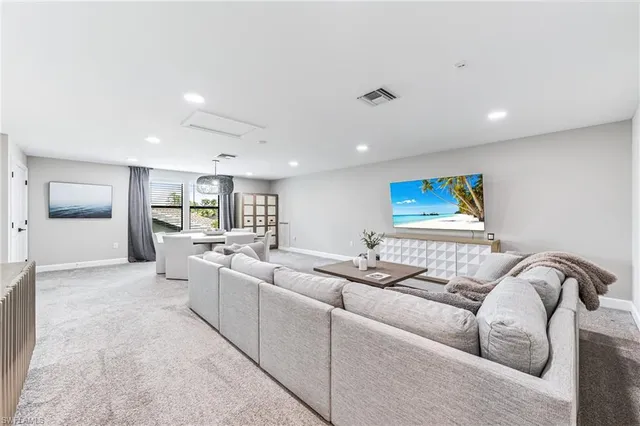 a living room with stainless steel appliances granite countertop a sink and cabinets