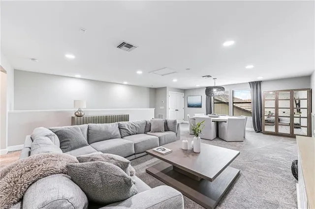 a living room with furniture a flat screen tv and a floor to ceiling window
