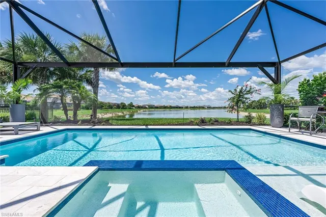 a view of a swimming pool with a table and chairs under an umbrella